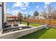 Landscaped backyard featuring a patio, seating area, and artificial grass, perfect for outdoor living and entertaining at 16402 E Tennessee Ave, Aurora, CO 80017