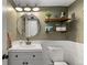 Charming bathroom features a stylish round mirror, open shelving, and a modern vanity for a refreshing space at 16402 E Tennessee Ave, Aurora, CO 80017