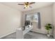 Cozy bedroom features soft carpet, ceiling fan, and a modern desk setup near a bright window at 16402 E Tennessee Ave, Aurora, CO 80017