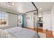 Sunlit bedroom featuring a four-poster bed, hardwood floors, and ensuite bath offers a luxurious and serene space at 16402 E Tennessee Ave, Aurora, CO 80017