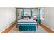 Stylish bedroom boasts a four-poster bed, wood floors, and bright teal accents for an elegant and inviting retreat at 16402 E Tennessee Ave, Aurora, CO 80017