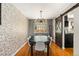 Elegant dining room with a large table, modern chandelier, and exposed brick accent wall at 16402 E Tennessee Ave, Aurora, CO 80017