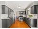 Modern kitchen featuring gray cabinets, stainless steel appliances, and hardwood floors at 16402 E Tennessee Ave, Aurora, CO 80017