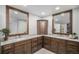 Bathroom featuring a double vanity with granite countertops, dark wood cabinetry, and framed mirrors at 5442 S Dayton Ct, Greenwood Village, CO 80111