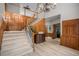 Grand foyer with wood paneling, staircase, and light hardwood floors that leads to a separate office at 5442 S Dayton Ct, Greenwood Village, CO 80111