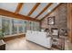 Cozy living room featuring exposed beams, a fireplace, and large windows for natural light and comfort at 5442 S Dayton Ct, Greenwood Village, CO 80111