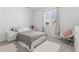 Comfortable bedroom featuring a queen-size bed, white furniture, and a cozy chair at 12314 Hayloft Ln, Thornton, CO 80241