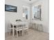Bright dining area with a white table, four chairs, and two windows with wood-look tile flooring at 12314 Hayloft Ln, Thornton, CO 80241