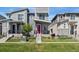 Modern townhome featuring gray siding, stone accents, a red front door, and well-maintained landscaping at 12314 Hayloft Ln, Thornton, CO 80241