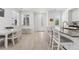 Bright, open kitchen and dining area featuring white cabinets, stainless steel appliances, and wood-look floors at 12314 Hayloft Ln, Thornton, CO 80241