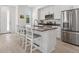 Well-lit modern kitchen with white cabinets, stainless steel appliances, gray countertops, and wood-look flooring at 12314 Hayloft Ln, Thornton, CO 80241