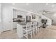 Open-concept kitchen with stainless steel appliances, white cabinetry, and a center island with bar seating at 12314 Hayloft Ln, Thornton, CO 80241
