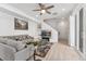Cozy living room featuring a comfortable gray sofa, ceiling fan, stylish rug, and glass coffee tables at 12314 Hayloft Ln, Thornton, CO 80241