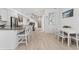 Bright, open living space featuring white walls, wood-look floors, dining area, and modern fixtures at 12314 Hayloft Ln, Thornton, CO 80241