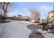 Large backyard with patio, partially covered by snow at 9573 Castle Ridge Cir, Highlands Ranch, CO 80129