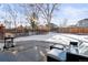 Backyard patio with seating area and grill, partially covered by snow at 9573 Castle Ridge Cir, Highlands Ranch, CO 80129