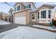 Two-story house with attached garage and snow-covered front yard at 9573 Castle Ridge Cir, Highlands Ranch, CO 80129