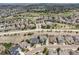 Aerial view of a neighborhood with lush greenery, mature trees, and a golf course in the distance at 8406 Winter Berry Dr, Castle Pines, CO 80108
