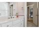 Bright bathroom with a large mirror, white marble counters, modern fixtures, and neutral wall paint at 8406 Winter Berry Dr, Castle Pines, CO 80108
