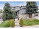 Charming two-story home with stone accents, lush landscaping, and inviting front yard on a sunny day at 8406 Winter Berry Dr, Castle Pines, CO 80108