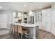 Bright, open kitchen featuring an island with seating, stainless steel appliances, and white cabinetry at 8406 Winter Berry Dr, Castle Pines, CO 80108