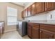 Functional laundry room with updated washer and dryer, dark wood cabinets, and ample counter space at 8406 Winter Berry Dr, Castle Pines, CO 80108