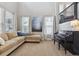 Bright and spacious living room featuring large windows, comfortable couch, and piano at 8406 Winter Berry Dr, Castle Pines, CO 80108