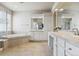 Luxurious bathroom with dual vanities, a soaking tub, and tiled floors at 8406 Winter Berry Dr, Castle Pines, CO 80108