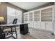Bright home office features custom built-in shelving and a modern glass desk at 8406 Winter Berry Dr, Castle Pines, CO 80108