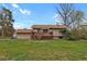 Exterior backyard view featuring a patio, large grassy area, and mature trees at 784 W Sterne Pkwy, Littleton, CO 80120