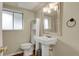 A light and airy bathroom with a pedestal sink, toilet and window at 784 W Sterne Pkwy, Littleton, CO 80120