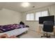 Cozy bedroom featuring a bed, desk with TV, and large window with blinds for natural light and privacy at 784 W Sterne Pkwy, Littleton, CO 80120