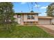 Charming home featuring manicured front lawn and an attached two-car garage on a sunny day at 784 W Sterne Pkwy, Littleton, CO 80120