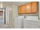 Functional laundry room with washer, dryer, and cabinets for storage, conveniently located near a doorway at 784 W Sterne Pkwy, Littleton, CO 80120