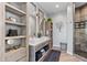A stunning bathroom with dual vanities, herringbone floors, a glass-enclosed shower, and stylish storage at 15295 E Cherry Creek S Rd, Larkspur, CO 80118
