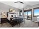 A bright primary bedroom boasts a tray ceiling, deck access, and neutral walls providing a serene retreat at 15295 E Cherry Creek S Rd, Larkspur, CO 80118