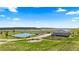 Idyllic country home with a tranquil pond, lush greenery, and clear blue skies in a scenic landscape at 15295 E Cherry Creek S Rd, Larkspur, CO 80118