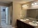 Well-lit bathroom features double sinks with large mirror, soaking tub, and walk-in closet access at 4746 Raven Run, Broomfield, CO 80023