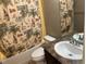 Well-lit bathroom with a beach-themed shower curtain, sink, and toilet at 4746 Raven Run, Broomfield, CO 80023