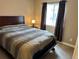 Comfortable bedroom with a classic bed, bedside table, and window with dark curtains at 4746 Raven Run, Broomfield, CO 80023