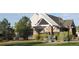 Community pool house exterior featuring white trim, stone accents and partial fencing at 4746 Raven Run, Broomfield, CO 80023