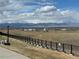 Panoramic view of the mountains and distant landscape from behind a black iron fence at 4746 Raven Run, Broomfield, CO 80023