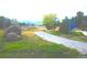 Community walking path with a welcome sign, trees, landscaping, and a bench at 4746 Raven Run, Broomfield, CO 80023
