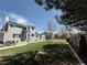 Large, grassy backyard with a patio, dining set and mature trees at 2050 Lake Circle Dr, Thornton, CO 80241