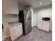 Well-lit kitchen features stainless steel fridge, white cabinets, and updated countertops at 2050 Lake Circle Dr, Thornton, CO 80241