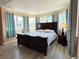 Spacious bedroom features a dark wood bed frame, large windows with curtains, and wood floors at 2050 Lake Circle Dr, Thornton, CO 80241