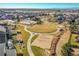 Aerial shot of community featuring lawns, volleyball court and pool at 16060 Fairway, Commerce City, CO 80022