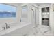 Bright bathroom featuring a soaking tub, glass enclosed shower and stylish marble floors at 16060 Fairway, Commerce City, CO 80022
