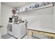 Functional laundry room with a washer, dryer, overhead shelf and a folding table at 16060 Fairway, Commerce City, CO 80022