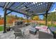 This stone patio features a fireplace, outdoor seating, and a pergola for shade at 16060 Fairway, Commerce City, CO 80022